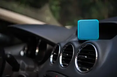 Small blue Bluetooth speaker on a car dashboard